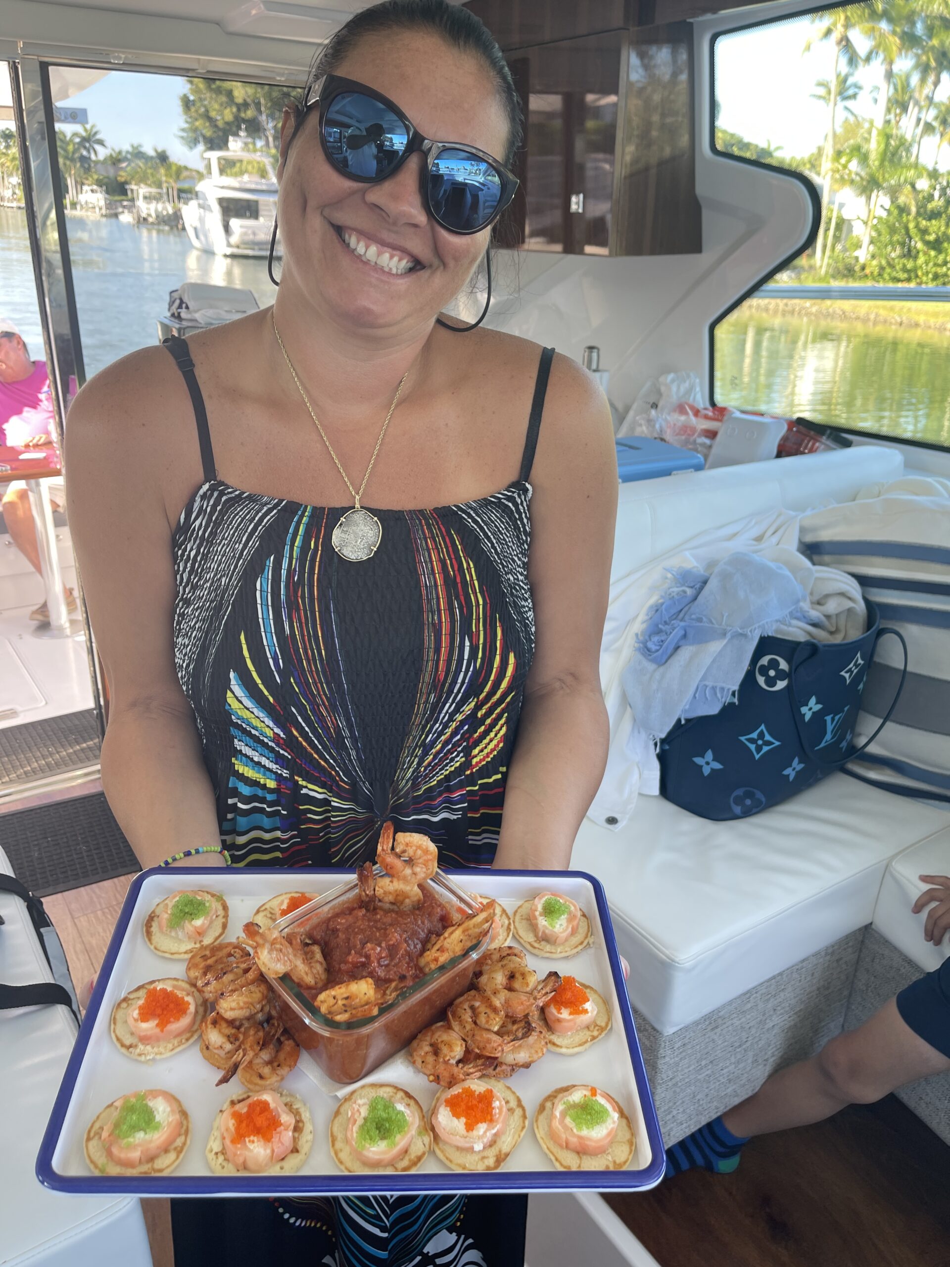 Noel, a full-time Stew/Chef with LivBlue, presenting a gourmet seafood platter aboard a luxury yacht, showcasing chef-prepared cuisine and premium hospitality on private charters.